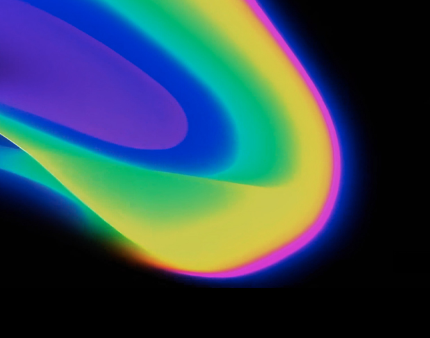 Abstract neon light trails in blue, green, yellow, and magenta sweeping across a black background, forming curved ribbons at the edge of the image.